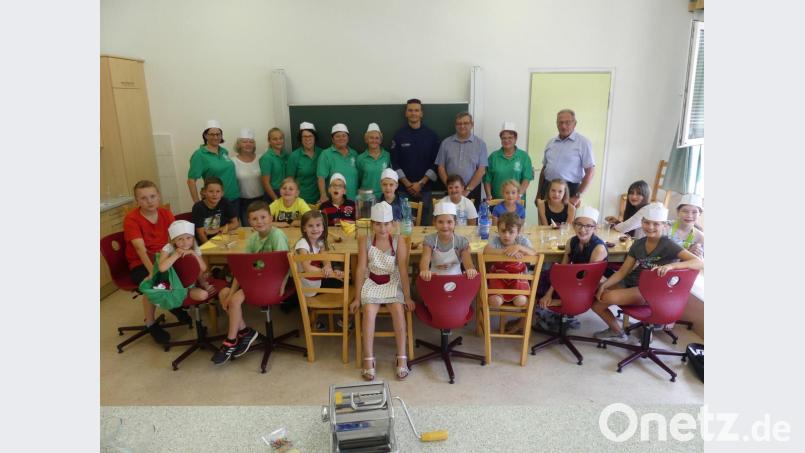 Mit Adriano Colella (Mitte) erleben die Kinder eine Kochstunde. Bild: rn