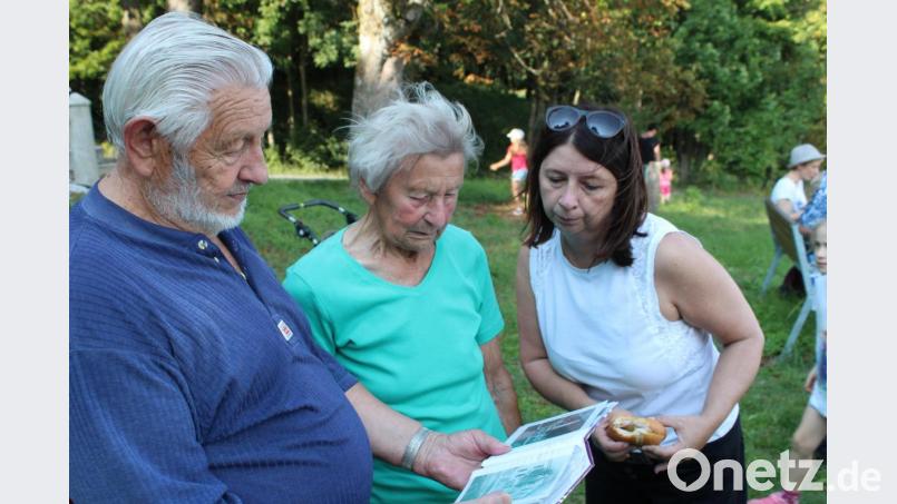 Zeitzeuge Ferdinand Zwerenz (links) schwelgt mit einer ehemaligen Bewohnerin von Paulusbrunn, der &quot;Schmuckerhof-Oma&quot;, in Erinnerungen. Auch eine Mutter, die bei der Wanderung mit dabei ist, interessiert sich für die Fotos aus vergangenen Tagen. Bild: Susanne Forster