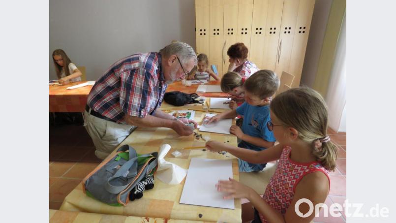 Wenn die Kinder beim Kleben ihrer Bilder ein Problem hatten, leisteten die Künstler gern Hilfestellung. Bild: ubb