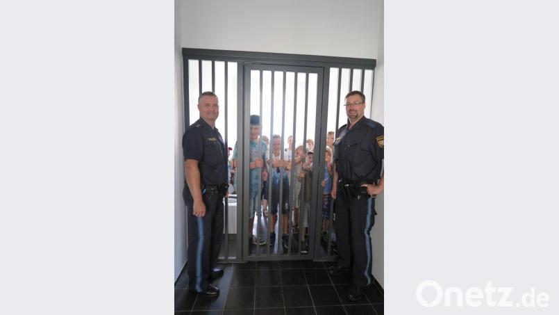 „Die Übernachtung in unserer Arrestzelle ist nicht kostenlos“, erklärten Polizeihauptkommissar Thorsten Filbinger (links) und Polizeihauptmeister Carsten Landgraf (rechts) den Kindern beim Rundgang durch die Dienststelle. Bild: jzk