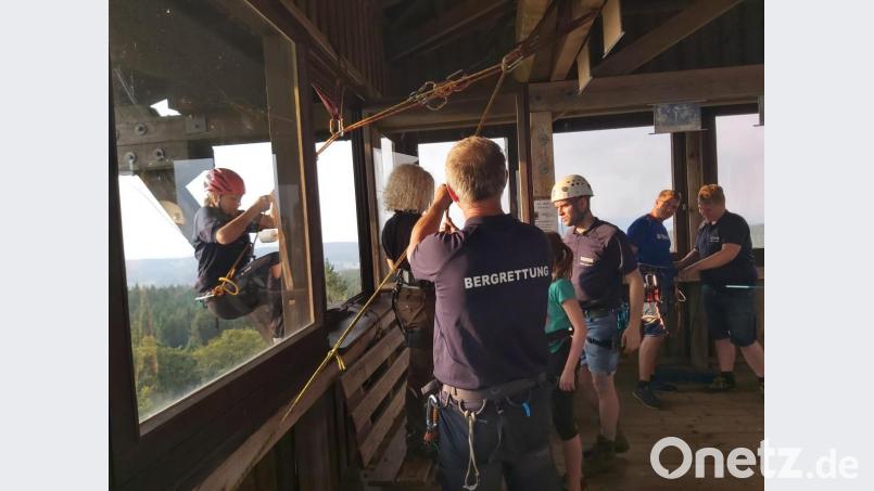Nicole Schafbauer lässt sich bestens gesichert von der Bergwacht Schönseer Land vom Böhmerwaldturm abseilen. Bild: eib