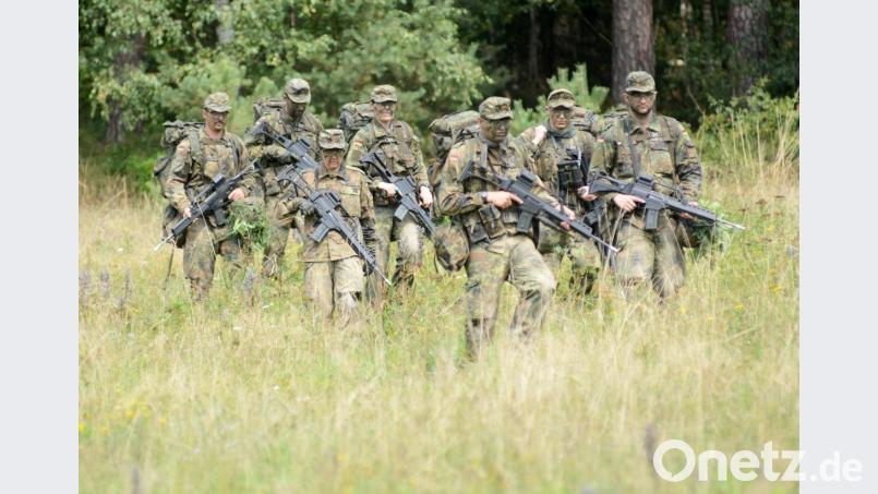 Durch kniehohes Gras marschieren die Teilnehmer einer Ausbildung für Reservisten auf dem Gelände der Kaserne in Pfreimd. Bild: Gabi Schönberger