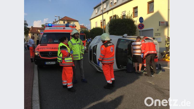 Die verletzte Fahrerin des umgestürzten weißen VW Tiguan wird von der Feuerwehr aus dem Fahrzeug befreit und dann vom Roten Kreuz ins Klinikum Weiden gebracht. Bild:  August Beer