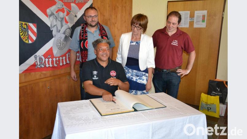 Die Vereinsvertreter tragen sich in das Goldene Buch des Marktes ein. Co-Trainer Eric Orie setzt gerade seine Unterschrift auf die Seite. Bild: ens