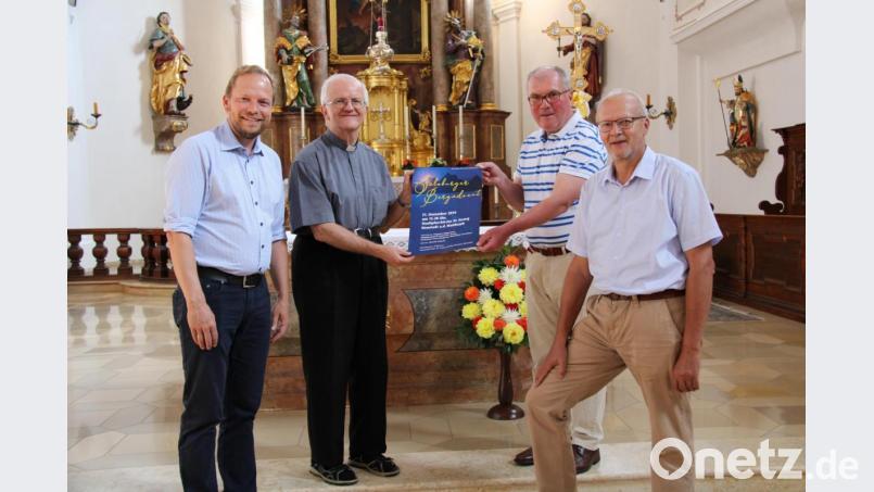 Kirchenpfleger Michael Kippes, Stadtpfarrer Josef Häring, Organisator Bertram Erhardt und Verwaltungsmitglied Bernhard Uhl (von links) präsentieren das Plakat des Salzburger Bergadvents, der am 21.12. mit österreichischen Volksmusikgruppen in der Stadtpfarrkirche organisiert wird. Bild: prh