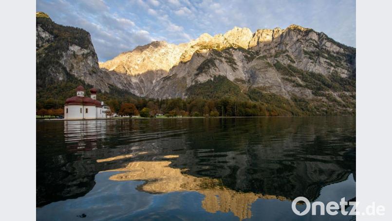 Die Kapelle Sankt Bartolomä am Königssee vor dem Watzmann, der von der Morgensonne angestrahlt wird. Auf dem Watzmann ist ein Bergsteiger aus Regensburg tödlich verunglückt. Bild: Lino Mirgeler/dpa