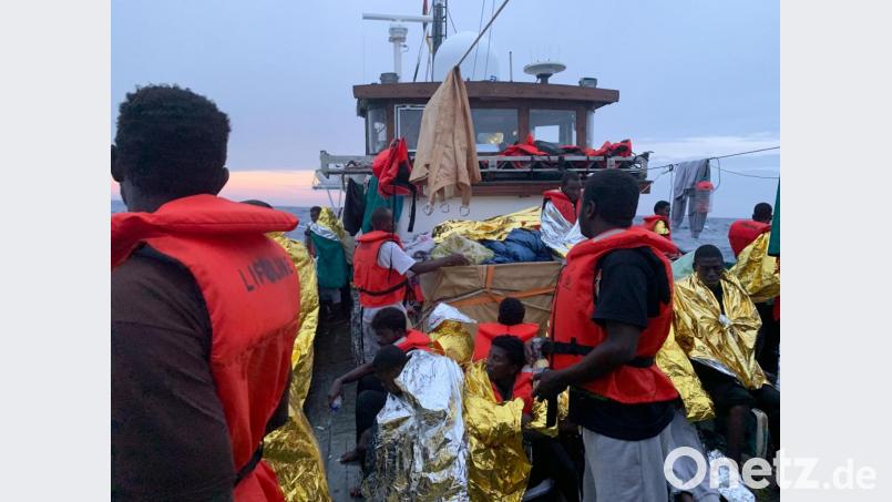 Nach einem Gewitter mit schweren Regenfällen schützen sich die rund 100 Migranten an Deck des Rettungsschiff "Eleonore" mit Rettungsdecken. Der Kapitän Claus-Peter Reisch hat auf der Eleonore den Notstand ausgerufen. Bild: Johannes Filous/dpa