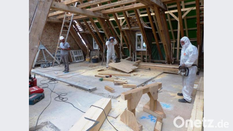 Mit Schutzanzug müssen die Zimmerer im Dachgebälk arbeiten. Bild: jp