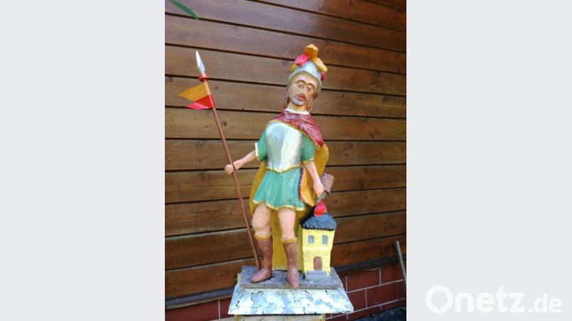 Die Figur bekam noch eine Fahnenstange aus dem Baumarkt in die Hand gesteckt, an der eine Fahne aus Lkw-Plane weht. Und dem Haus, das Florian mit einem Kübel Wasser rettet, spendierte Opa Förster eine Treppe. Bild: tat