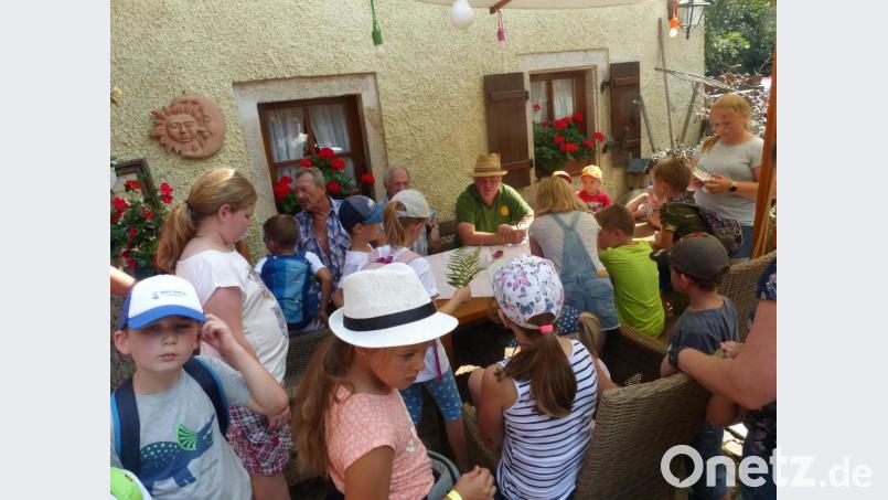 OWV-Vorsitzender Michl Schwabl und Mühlenbesitzer Heribert Lindner (sitzend, von rechts) erwarten die Kinder im Hof des Anwesens. Bild: sl