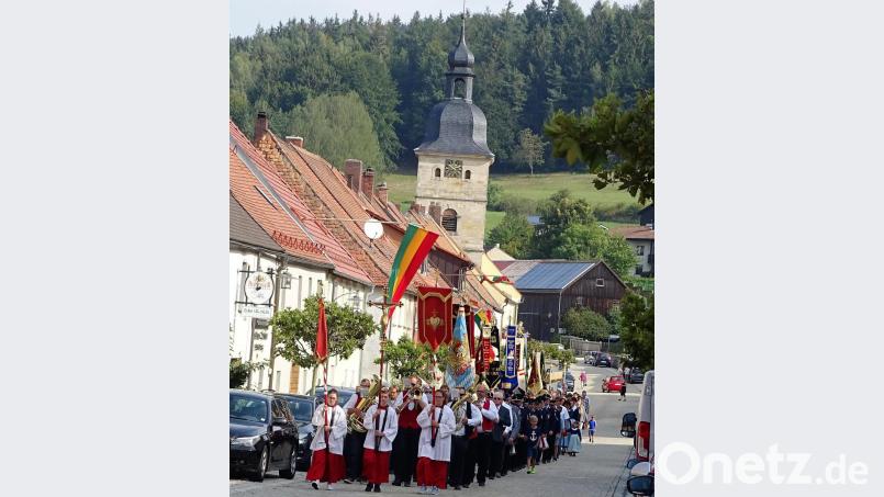 Prozession durch den Markt mit Pfarrer Stretz mit der Monstranz unter dem Traghimmel. Bild: hl