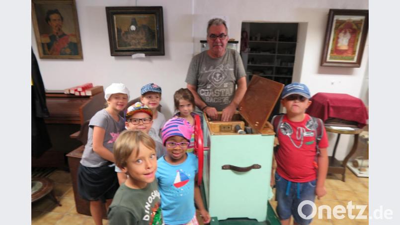 Museumsleiter Anton Heindl zeigte den Kindern, wie sie der mechanischen Drehorgel (Partyorgel) Tön entlocken können. Bild: jzk
