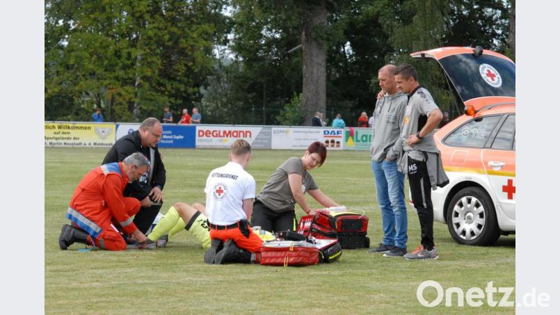 Jahn-Trainer Mersad Selimbegovic (von rechts) und sein Zwickauer Kollege Joe Enochs schauen betroffen, wie der schwer verletzte Sascha Härtel noch auf dem Platz notversorgt wird. Bild: gb