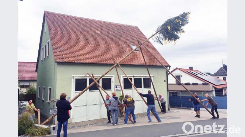Die Männer wuchten den Kirwabaum in die Höhe. Bild: ü