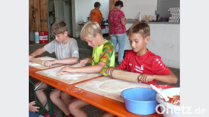 Nachdem der Teig ausgerollt war, durften die Kinder ihre Pizza nach eigenem Geschmack belegen. Bild: amö