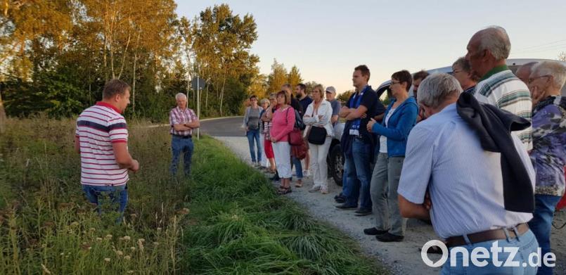 Beim Umwelttag der CSU erklärte Landwirt Thomas Weiß (Vordergrund) auf der zweiten Station die von ihm angelegte Blühfläche. Zuvor bekamen die zahlreichen Anwesenden einen Einblick in die Situation der Kleingärtner von Tobias Meidinger (Sechster von rechts). Bild: exb