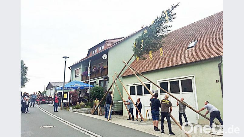 Die Männer wuchten den Kirwabaum in die Höhe. Bild: ü