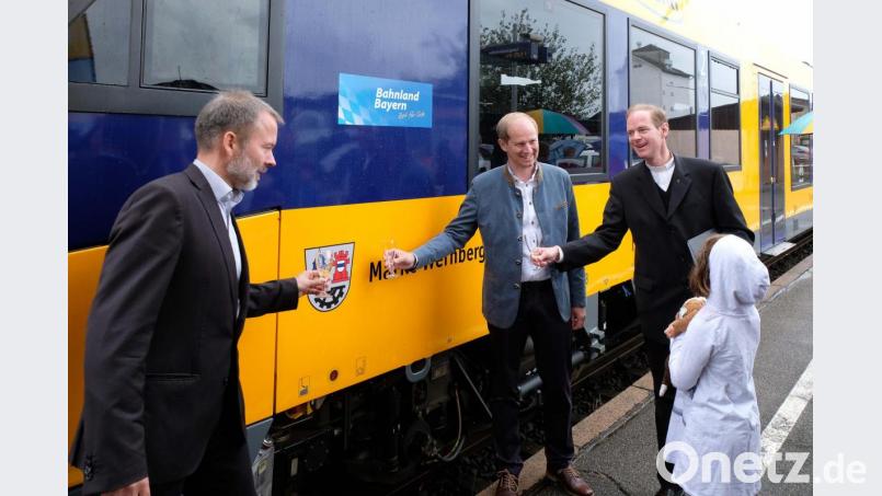 Geschäftsführer Wofgang Pollety, Bürgermeister Konrad Kiener und Pfarrer Matthias Weih taufen den Zug mit Sekt Bild: twi