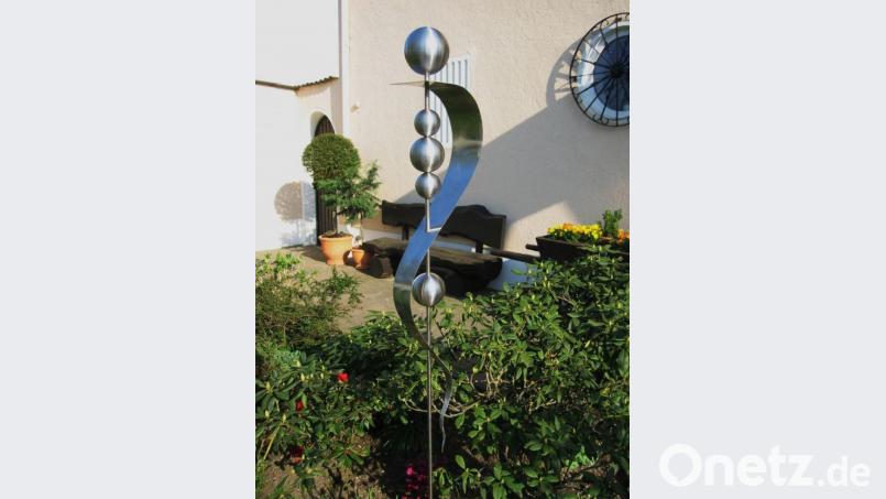 Geschwungene Muster: Zwischen den Büschen ragt ein Gartenstecker aus Edelstahl hervor. Bild: exb