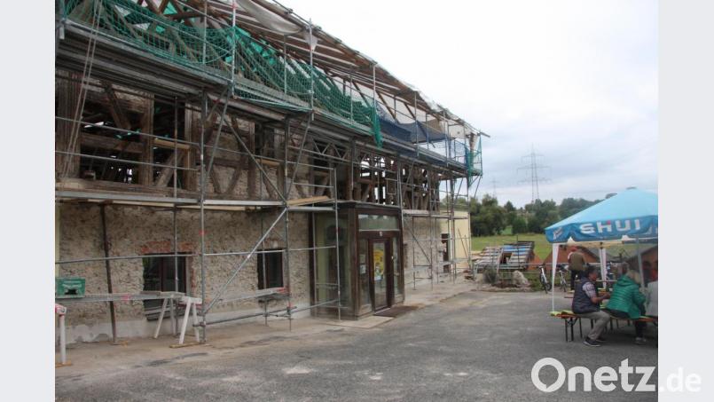 Draußen sitzen, um eine Wanderpause einzulegen, ist bereits möglich. Dass die Hammermühle derzeit eine Baustelle ist, stört die Ausflügler nicht. Bild: wro