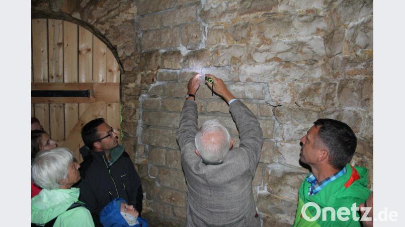 Eckart von Eyb zeigt die restaurierte Mauer - bewusst anders strukturiert, um nachvollziehen zu können, wo das Original und wo die Erneuerung ist. Bild: wec