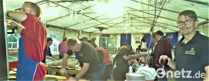 Das Team der Pizzabäckerei um Manfred Krauß (links) hatte an dem Abend alle Hände voll zu tun. Herbert Riedel (rechts) vom Siedlervorstand genießt derweil seinen Rotwein. Bild: jml