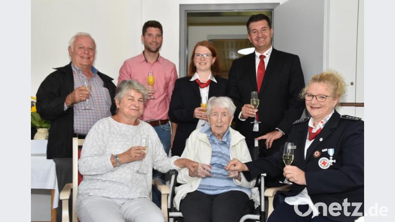 Sophie Krapf feiert im Kreis ihrer Rotkreuz-Kameraden. Außerdem gratulieren zum 95. Geburtstag Tochter Barbara Schilhabel (vorne, links) und Heimleiter Denis Parchomenko (hinten, Zweiter von Links). Bild: hcz