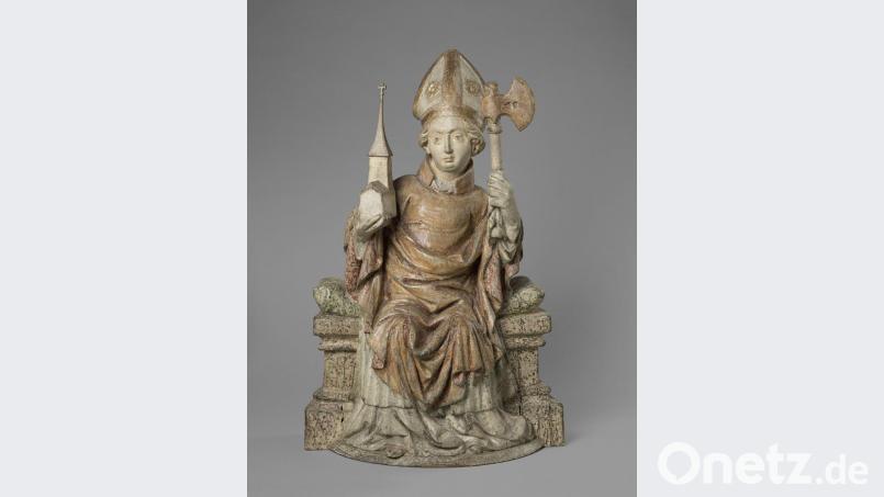 Die Holzfigur des Heiligen Wolfgang wird in der Bayerischen Landesausstellung in Regensburg zu sehen sein. Man erkennt den Heiligen gut an seinen beiden Attributen, der Kirche und dem Beil. Bild:  Musée du Louvre, Dist. RMN – Grand Palais / Sylvie Chan-Liat