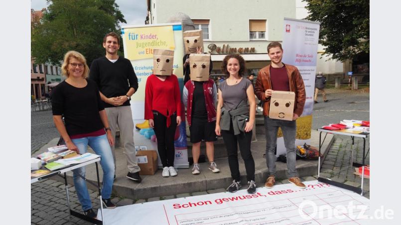 Mit einer Papiertütenaktion und anderen Aktivitäten präsentieren sich drei lokale Beratungsstellen für psychische- und Suchtprobleme. Mit dabei anonyme Passanten unter Papiertüten und (von links) Diplomsozialpädagogin Ursula Breinbauer, Diplom-Psychologe Sebastian Babl, Sozialpädagogin Franziska Pausch und Psychologiestudent Benedikt Gailer. Bild: Bühner