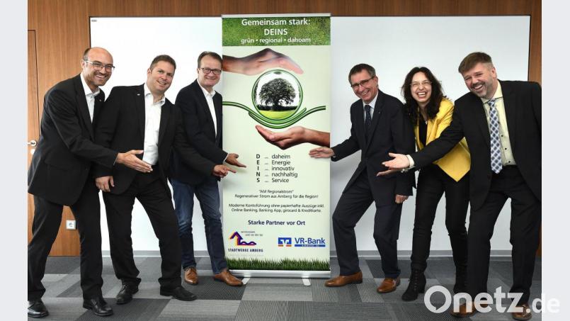 VR-Bank-Vertriebsleiter Markus Hirsch, -Marketingchef Thomas Retzer, -Vorstand Dieter Paintner, Stadtwerke-Geschäftsführer Stephan Prechtl, Violetta Meyer und Vertriebsleiter Thomas Reiß (von links), ebenfalls von der städtischen Tochtergesellschaft, präsentieren ihr neues gemeinsames Kind namens DEINS. Es rangiert auch auf dem Werbebanner unter dem Motto „grün, regional, dahoam“. Bild: Petra Hartl