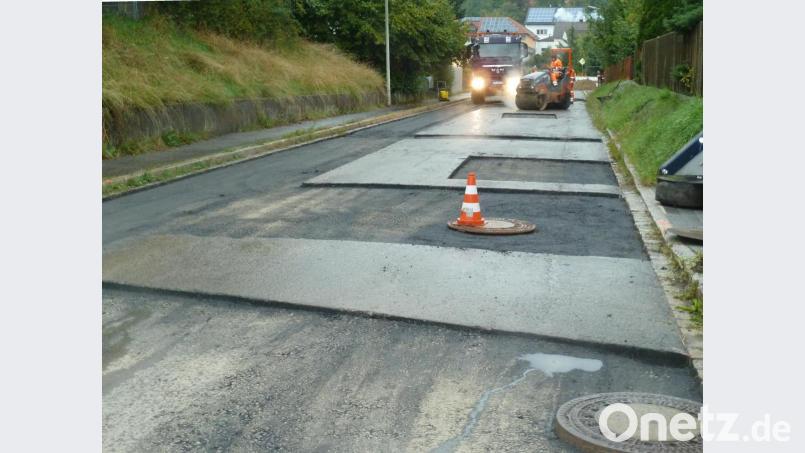 Ende des Fleckenteppichs: Bei strömendem Regen wurde am Montag die Eigelsberger Straße provisorisch asphaltiert. Der Ausbau der Straße lässt allerdings auf sich warten. Bild: Portner