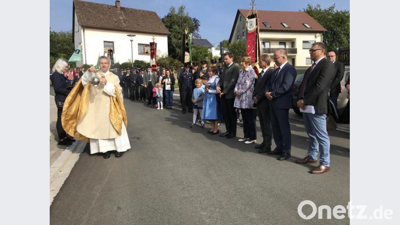 Pfarrer Markus Schmidt segnet symbolisch für alle Maßnahmen eine der sanierten Straßen; unter den Gästen die Landtagsabgeordneten Stephan Ötzinger und Annette Karl, der stellvertretende Landrat Albert Nickl und der stellvertretende Leiter des Amtes für Ländliche Entwicklung, Baudirektor Erik Bergner (rechts). Bild: eig