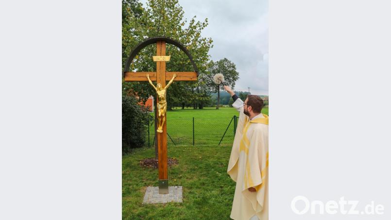 Pfarrer Dominik Mitterer segnet das frisch restaurierte Dorfkreuz in Altmannshof. Bild: chl