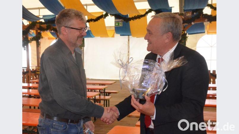 Der Bezirksvorsitzende der Schausteller und Marktkaufleute, Georg Duschinger, schenkt Oberbürgermeister Kurt Seggewiß leuchtende Wappen der Stadt Weiden und der Marktkaufleute. Bild: Kunz
