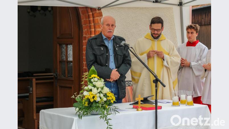 Der Vorsitzende des Fördervereins Dorfkapelle, Gerd Weiß, erzählt den Gästen ein bisschen von der Geschichte des Dorfkreuzes. Bild: chl