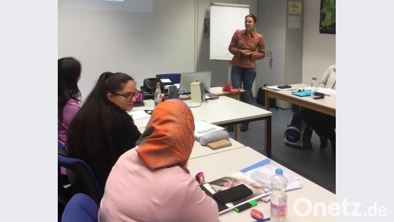 Auswege aus der Mobbing-Falle zeigte die Psychologin Yvonne Straller-Höhlein vom Deutschen Kinderschutzbund (hinten stehend) auf. Die Teilnehmer des Elternintegrationskurses der VHS Amberg-Sulzbach hörten aufmerksam zu und diskutierten engagiert über dieses Thema. Bild: cog