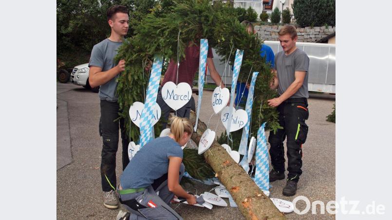 Kirwaburschen brachten die Kränze am Kirwabaum an. Ein Kirwamoidl brachte noch schnell Ordnung in die mit den Namen der Kirwapaare beschrifteten Herzen. Bild: sön