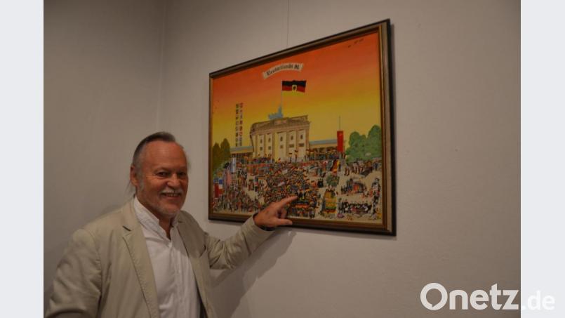 Adolf Ritz vor seinem Wimmelbild &quot;Deutschlands 90er&quot;. Im Vordergrund deutet er auf Helmut Kohl und Hans-Dietrich Genscher. Bild: inl