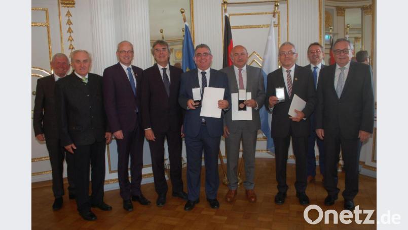 Norbert Bücherl (mit Medaille, von links), Georg Götz und Michael Götz nahmen die Auszeichnung in Regensburg von Regierungspräsident Axel Bartelt (Vierter von links) entgegen. Weitere Amtsträger gratulierten. Bild: gib