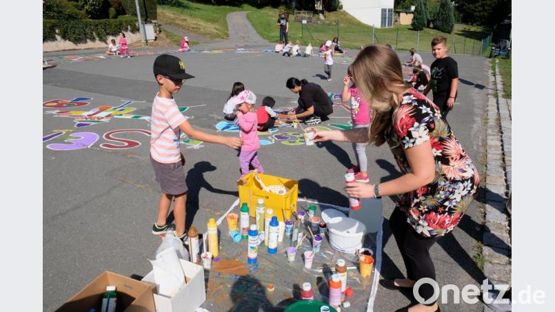 Künstlerisch einfallsreich und kreativ geht es zu beim nachgeholten Straßenmalen im Zuge des städtichen Ferienprogrammes. Zeitweise verwandeln bis zu 50 Mädchen und Buben den Straßenasphalt vor dem Kindergarten in eine bunte Blumen- und Buchstabenwiese. Bild: do