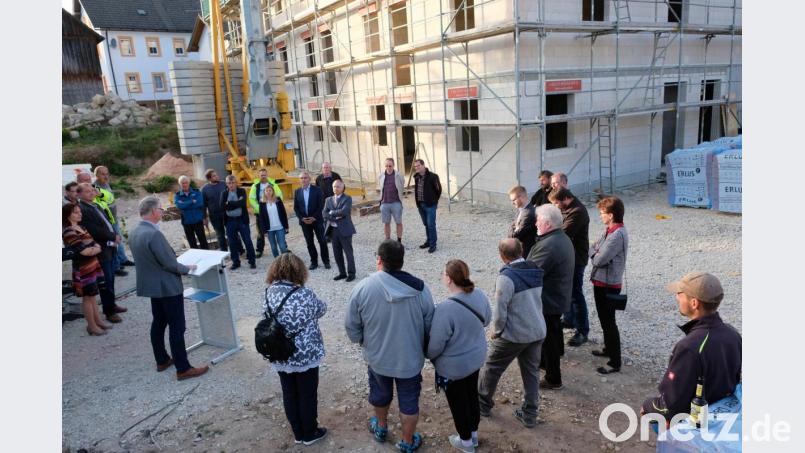 Zahlreiche Gäste, unter ihnen die &quot;Geldgeber&quot; vom Amt für Ländliche Entwicklung, kommen zum Richtfest für das kommunale Neun-Familien-Wohnhaus. Bürgermeister Werner Roder (links am Rednerpult) würdigt dabei den Einsatz aller am Bau beteiligten Institutionen, Planer und Handwerker. Bild: do
