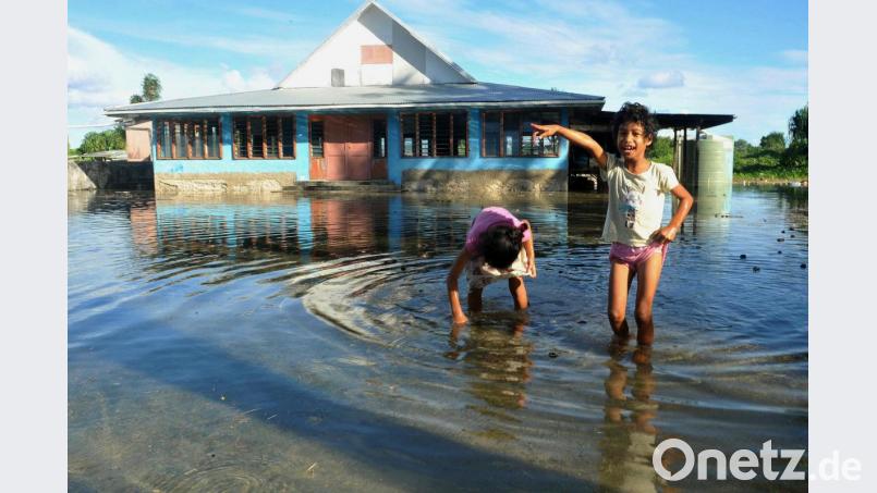 Kinder spielen auf einem vom Meerwasser überfluteten Platz in Funafuti, der Hauptstadt des pazifischen Inselstaats Tuvalu. Foto: Kyodo/Archiv Bild: Kyodo