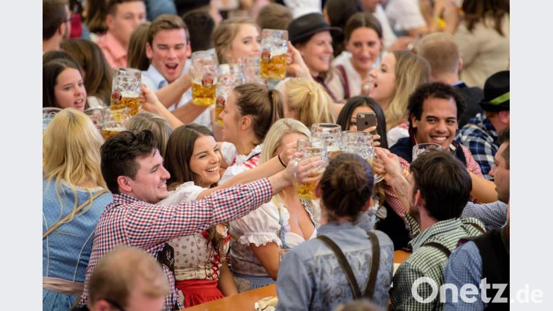 Besucher stoßen im Paulaner-Festzelt mit ihrer ersten Mass Bier an. Bild: Matthias Balk/dpa
