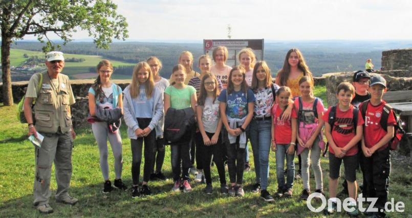 Uwe Schimpf (links) vom Heimat- und Kulturverein erläuterte den Ministranten aus Waldeck und Kastl die Geschichte der Burganlage auf dem Schloßberg sowie die bislang erfolgten Restaurierungsarbeiten an der Ruine. Bild: hl