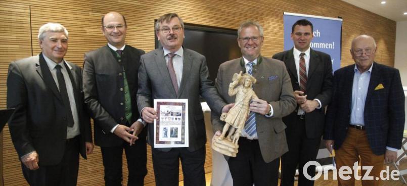 Vorsitzender Gerd Hampl (Dritter von links) überreichte Oberbürgermeister Andreas Feller eine geschnitzte Holzfigur des "Wastls", der Symbolfigur der Falkenauer. Mit dabei waren MdB Karl Holmeier, Heimatminister Albert Füracker, Landrat Thomas Ebeling und Festredner Johann Böhm (von links). Bild: Hirsch