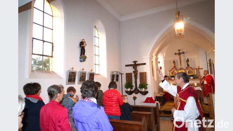 Segnung der restaurierten Figur des Heiligen Antonius (links zwischen den Kirchenfenstern) durch Pfarrer Norbert Götz. Bild: fvo