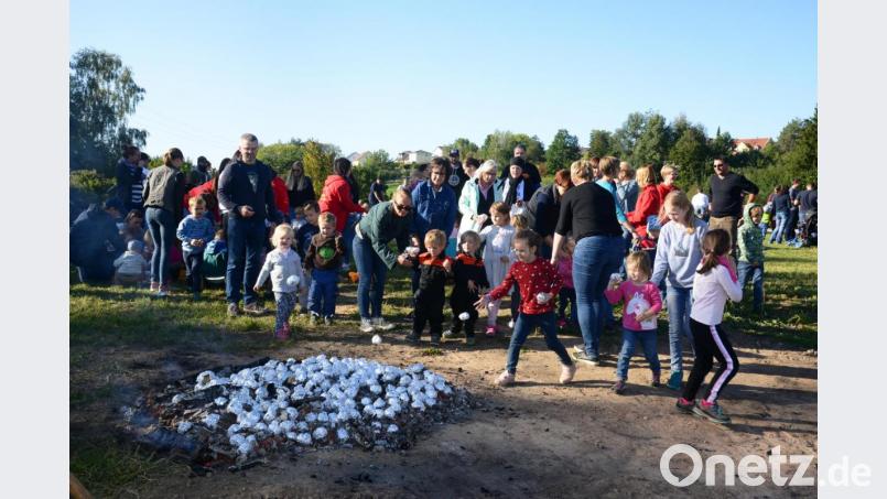 Begeistert werfen die Kinder die in Alufolie eingewickelten Kartoffeln ins Feuer. Bild: bey