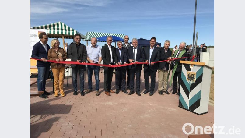 Bürgermeister Günter Stich (Vierter von rechts) zückt die Schere und mit ihm durchschneiden Vertreter der an Ausweisung, Planung und Bau Beteiligten das symbolische rote Band: "Auf eine gute Zukunft!" Bild: eig