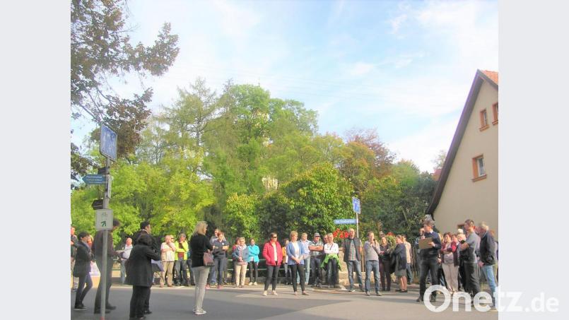Stadtheimatpfleger Bernd Piehler (rechts mit Mappe und Mikrophon) informiert die Gruppe beim Halt am Stadtweiher über die Brände. Bild: tu