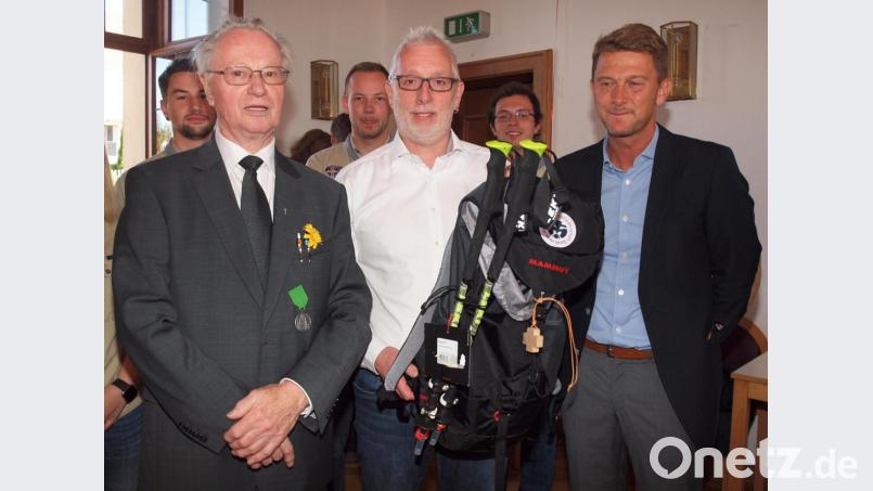 Die Altpfadis David Breitkopf und Thomas Göldner übergaben Pfarrer Hermann Sturm einen Rucksack, „damit Sie in Oberbayern gut unterwegs sind“. Bild: sön
